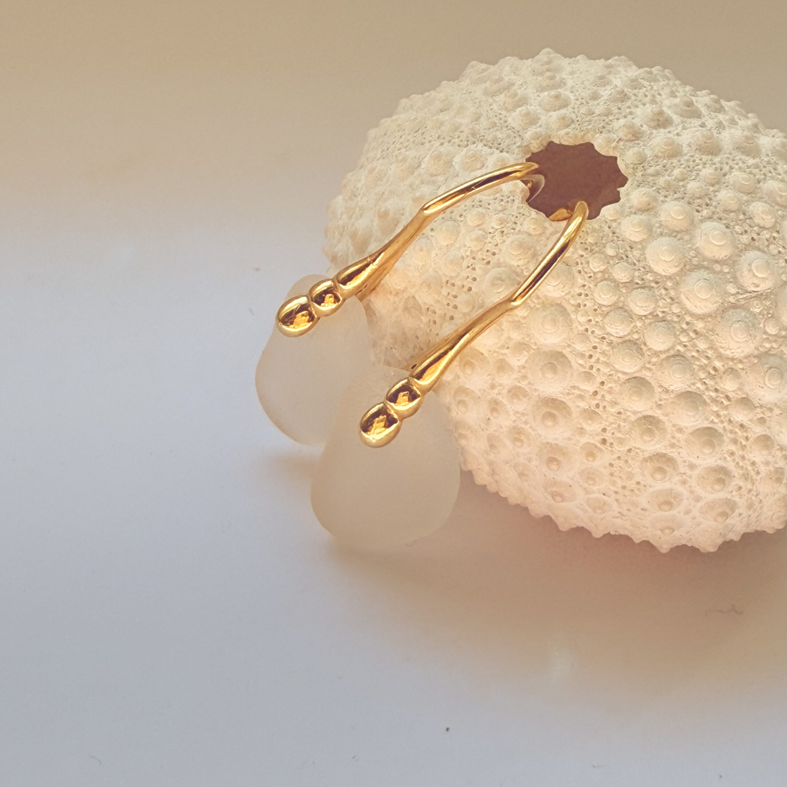 witte zeeglas oorbellen met gouden decoratieve oorhaakjes