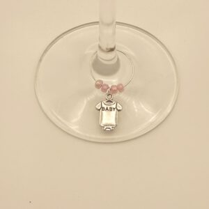 Wijnglasring met baby-rompertje bedeltje, gedragen aan een wijnglas