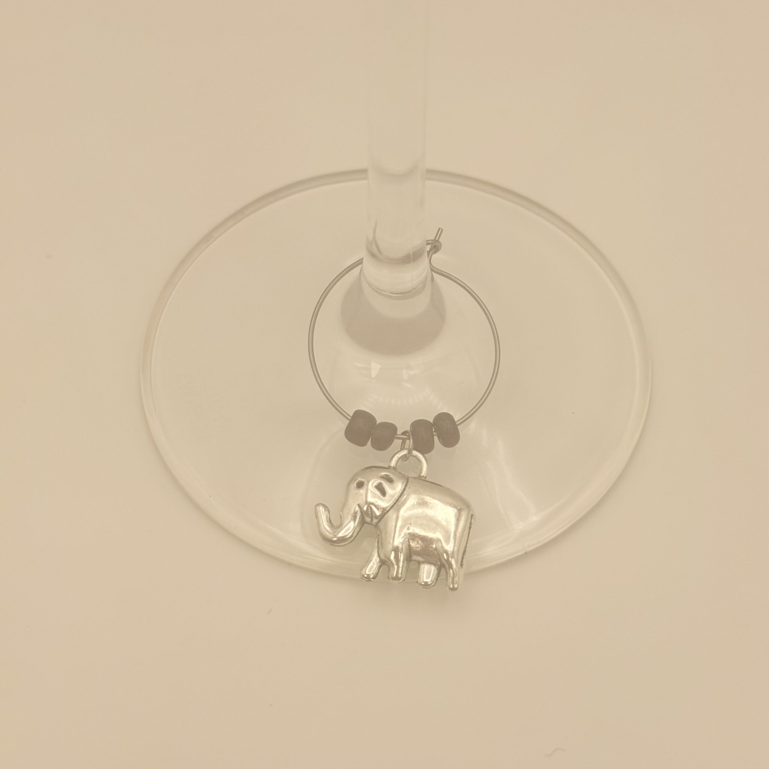 Wijnglasring met olifant-bedeltje, gedragen aan een wijnglas