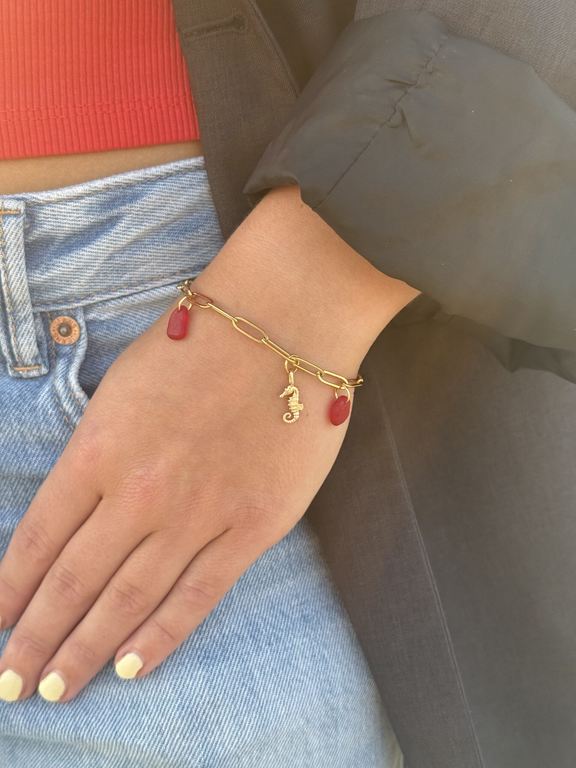 Ocean Charms armband met rood zeeglas, close-up om de pols